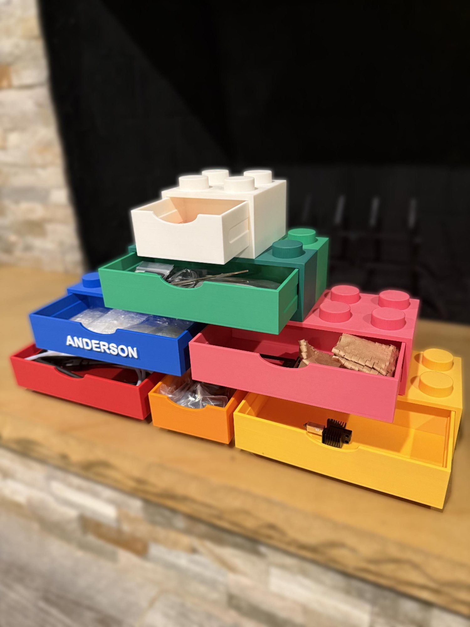 Brick storage drawers pulled open holding pens, hardware, and small parts