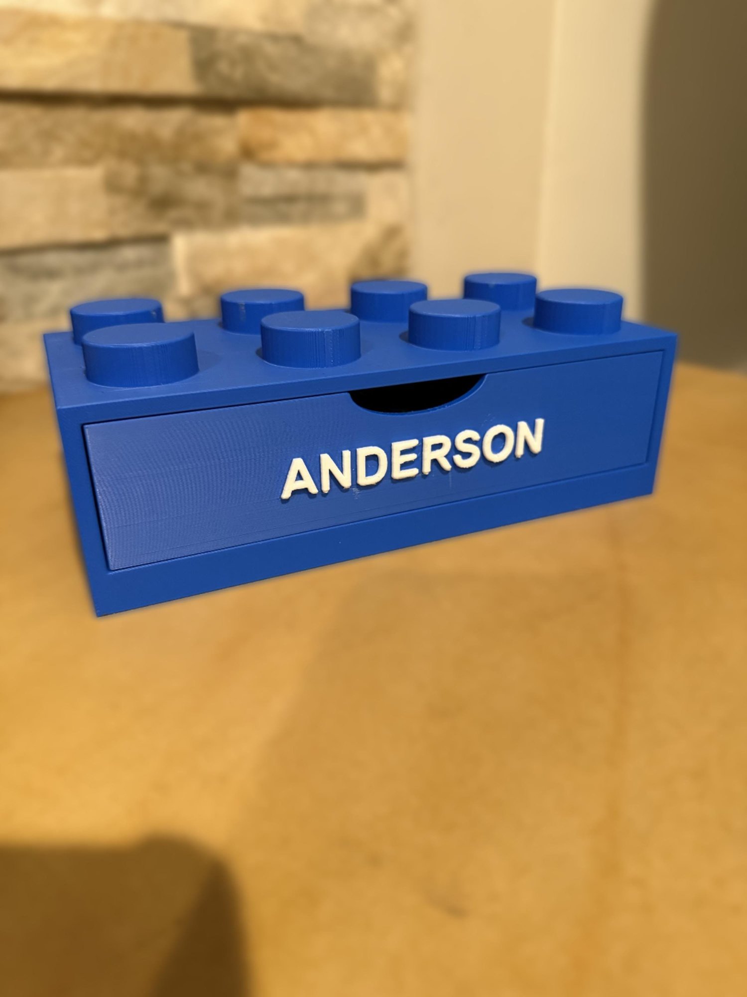 Close-up of a blue 4x2 brick drawer personalized with the name Anderson in raised white lettering